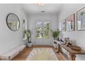 Bright foyer with elegant decor, including a decorative rug, stylish bench and sun-filled front door at 1530 Willtown St, Daniel Island, SC 29492