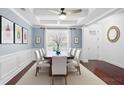 Formal dining room with elegant decor, wainscoting, tray ceiling, and seating for eight at 158 Netherfield Dr, Summerville, SC 29486
