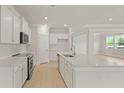 Modern kitchen featuring white cabinets, stainless steel appliances, and a large island with quartz countertops at 205 Bilge Rd, Ridgeville, SC 29472