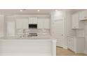 Bright kitchen featuring white cabinets, quartz countertops, stainless steel appliances, and hardwood floors at 205 Bilge Rd, Ridgeville, SC 29472