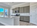 Bright kitchen features gray cabinets, stainless appliances, white countertops, and ample natural light at 215 Bilge Rd, Ridgeville, SC 29472