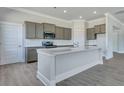 Modern kitchen with gray cabinets, stainless appliances, and a large island with white countertops at 215 Bilge Rd, Ridgeville, SC 29472