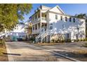 Exterior of a two-story home with white siding and a brick driveway leading to a basement-level garage at 2356 Hut Creek Rd, Johns Island, SC 29455