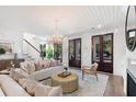 Cozy living room featuring a fireplace, chandelier, and dark-stained French doors leading to the exterior at 2356 Hut Creek Rd, Johns Island, SC 29455