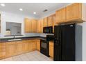Well-lit kitchen featuring wood cabinets and black appliances at 241 Howle Ave # G, Charleston, SC 29412