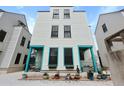 A three-story home featuring bright turquoise accents, a gravel driveway, and meticulous landscaping at 3 1/2 Maranda Holmes St # B, Charleston, SC 29403