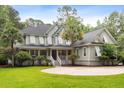 Attractive two-story home featuring a large front lawn, covered porch with white railings, and classic architectural details at 3171 Pignatelli Cres, Mount Pleasant, SC 29466