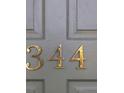 Close-up of the house number '344' in gold lettering on a grey door at 344 Canterbury Rd, Charleston, SC 29407