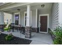 Inviting front porch with rocking chairs, stone accents, and a welcoming entrance at 357 Beachgrass Ln, Summerville, SC 29486