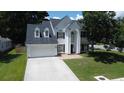 Traditional two-story home with a two-car garage, well-manicured lawn, and mature shade trees at 407 Thomaston Ave, Summerville, SC 29485