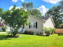Side view of a well-maintained home boasting a lush lawn, a cozy porch, and tasteful landscaping at 4457 Rice Mill Dr, North Charleston, SC 29420