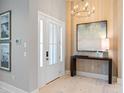 Bright entryway featuring wood accent wall, chandelier, console table with art, and an 8-lite glass door at 4848 Woodville Rd, Awendaw, SC 29429