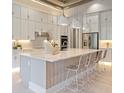 Gourmet kitchen with white cabinets, marble countertops, stainless steel appliances, and a large central island at 4848 Woodville Rd, Awendaw, SC 29429