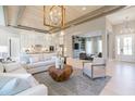 Open-concept living room flowing into the kitchen with modern decor, wood ceiling detail, and hardwood floors at 4848 Woodville Rd, Awendaw, SC 29429
