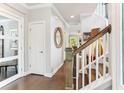 Elegant hallway with hardwood floors, white trim, and a staircase leading upstairs at 542 Amalie Farms Dr, Charleston, SC 29492