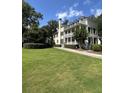 Stately multi-story home with a well-manicured lawn, covered porches, and lush landscaping at 578 Island Walk East, Mount Pleasant, SC 29464
