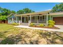 Beautiful single-story home featuring a welcoming porch with rocking chairs and manicured landscaping at 762 Swanson Ave Ave, Charleston, SC 29412