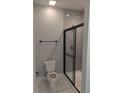 Well-lit bathroom featuring a toilet and glass-enclosed shower with gray subway tiles at 7763 Park Gate Dr, North Charleston, SC 29418