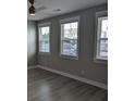 Bright bedroom with three large windows, hardwood floors, and neutral wall color at 7763 Park Gate Dr, North Charleston, SC 29418