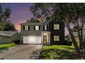 Charming two-story home with a two-car garage and a well-manicured front yard at dusk at 8044 Old London Rd, North Charleston, SC 29406