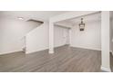 Bright living room with gray floors, white walls, open stairs and a decorative chandelier at 8044 Old London Rd, North Charleston, SC 29406