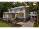 Beautiful two-story home with a metal roof, a garage, and mature landscaping at dusk at 8187 Jack Island Dr, Johns Island, SC 29455