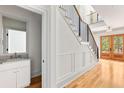 Foyer with staircase, powder room, and hardwood floors leading to double glass doors at 8187 Jack Island Dr, Johns Island, SC 29455