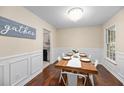 Dining area with wainscoting and hardwood flooring; wood table, stylish chairs, and a modern chandelier at 105 Spring St, Summerville, SC 29485