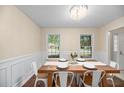 Dining area with wainscoting and hardwood flooring; a wood table, stylish chairs, and natural light at 105 Spring St, Summerville, SC 29485