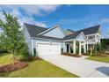 Beautiful two-story home with manicured lawn and a welcoming front porch, perfect for relaxing outdoors at 1056 Tea Time Dr, Summerville, SC 29485