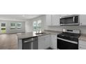 Bright kitchen featuring white cabinets, granite countertops, and stainless steel appliances at 143 Haventree Ct, Summerville, SC 29486