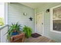 Inviting front porch with plants and seating outside the front door at 2329 Tall Sail Dr # 704D, Charleston, SC 29414