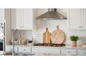 Close-up of kitchen countertop with stainless steel faucet, modern cooktop, and stylish decor at 304 Archar St, Summerville, SC 29486
