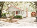 Quaint home with red door, covered porch, and matching storage shed at 317 Bay St, Walterboro, SC 29488