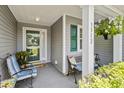 Inviting front porch with seating, decorative plants, and stylish front door with wreath at 3312 Telford Ct, Summerville, SC 29485