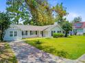 Single-story home with neat landscaping, driveway, and a backdrop of lush trees create a welcoming curb appeal at 405 Amberjack Way, Summerville, SC 29485