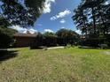 Expansive backyard with a brick home, covered patio, mature trees, and a shed at 409 Azalea Dr, Walterboro, SC 29488