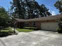 Charming brick home featuring an attached garage, green shutters, and concrete driveway at 409 Azalea Dr, Walterboro, SC 29488