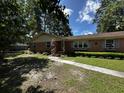 Charming brick home featuring an attached garage, green shutters, and manicured lawn at 409 Azalea Dr, Walterboro, SC 29488