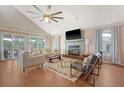 Bright living room featuring a fireplace, ceiling fan, hardwood floors, and large windows at 4636 Ashley View Ln, North Charleston, SC 29405