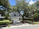 Charming two-story home featuring a two-car garage, white exterior, and a beautiful mature tree in the front yard at 641 Magnolia Rd, Charleston, SC 29407