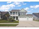 Inviting two-story home with a charming front porch, landscaped lawn and a two car garage at 658 Yellow Leaf Ln, Summerville, SC 29486