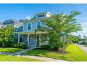 Two-story home with blue siding, inviting front porch, and lush landscaping on a sunny day at 72 Crossandra Ave, Summerville, SC 29483