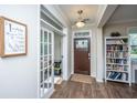 Bright foyer featuring hardwood floors, a charming bookshelf, and access to a storage area at 72 Crossandra Ave, Summerville, SC 29483