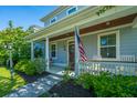 Inviting covered front porch with white columns, a cozy swing, and view of the manicured front yard at 72 Crossandra Ave, Summerville, SC 29483