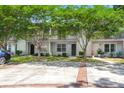 Charming two-story condo with white siding, a walkway, mature trees, and a private second-story balcony at 7814 Nummie Ct, North Charleston, SC 29418