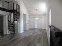 Bright living room boasts new flooring, soaring ceilings, and spiral staircase leading to upper level at Way, Goose Creek, SC 29445