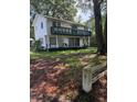 A two-story house features a spacious balcony and a large yard enclosed by a rustic wooden fence at 102 Webb St, Bonneau, SC 29431