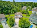 Aerial view of a two-story home in a lush, green neighborhood with mature trees and well-maintained lawns at 104 Study Ct, Ladson, SC 29456