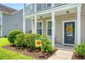 Inviting front porch with a sunflower wreath, complemented by lush landscaping at 109 Cypress Plantation Rd, Moncks Corner, SC 29461